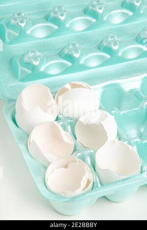 A close-up of a set of cracked white eggshells individually nestled on cores of styrofoam tray. Stock Photo