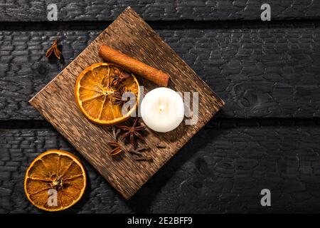Winter spices concept. Flat lay view of various spices: cinnamon stick, clove, star anise, dried orange slices. Wood plate with seasonal potpourri. Stock Photo