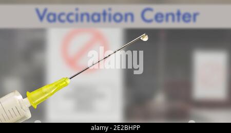 COVID-19 vaccine injection, syringe with corona serum in front of vaccination center, symbol picture Stock Photo