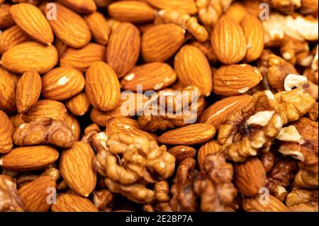 Almonds and walnuts scattered on the table. Close-up, selective focus Stock Photo
