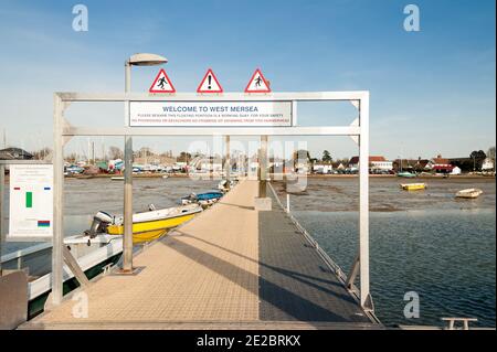 WEST MERSEA, ESSEX, UK - APRIL 05, 2009:  View along the jetty back toward the island with welcome sign Stock Photo