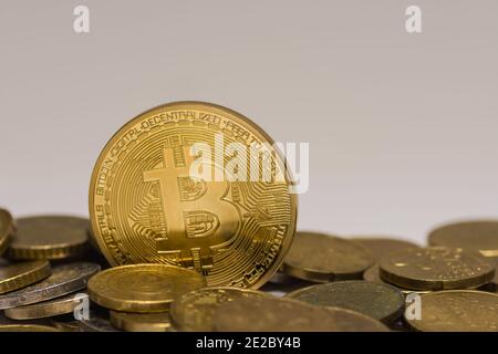 golden valuable bitcoin standing between other coins detail view Stock Photo