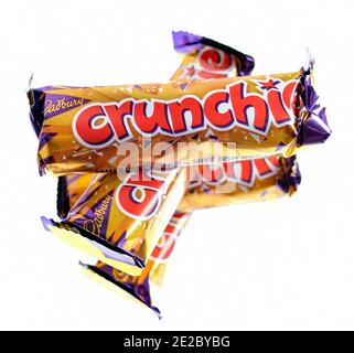 Norwich, Norfolk, UK – December 24 2020. An illustrative editorial photo of a close up of a stack of Cadbury Crunchie bars on a plain white background Stock Photo