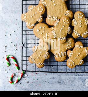 Overhead of gingerbread cookies on wire rack on grey stone counter. Stock Photo
