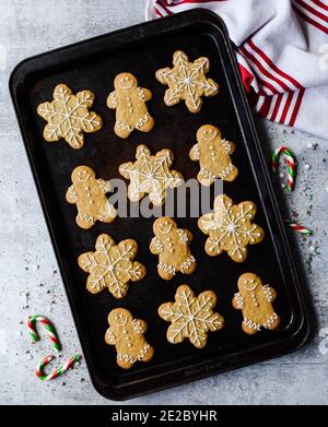Overhead of gingerbread cookies on sheet pan on grey stone counter. Stock Photo