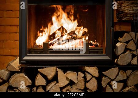 Close-up of a burning fireplace on the brick wall background Stock Photo