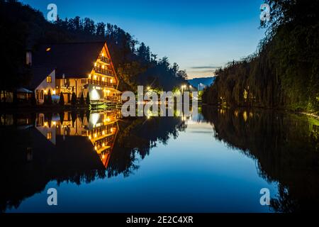 Cabin and dramatic sky at the blue hour mirrored in the lake. Photo taken on 9th of October 2020 in Moneasa, Arad county, Romania. Stock Photo
