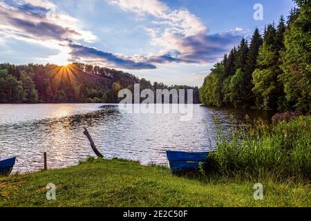View of the artificial mountain lake Trei Ape during a dramatic warm sunset.  Photo taken on 5th of July 2020 at the Trei Ape lake, Caras-Severin coun Stock Photo