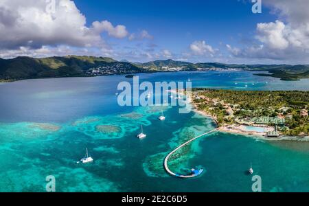 Beach in Caribbean island bay in Antilles with transparent turquoise sea water and coral reefs, aerial drone panorama, white sand and coconut palm tre