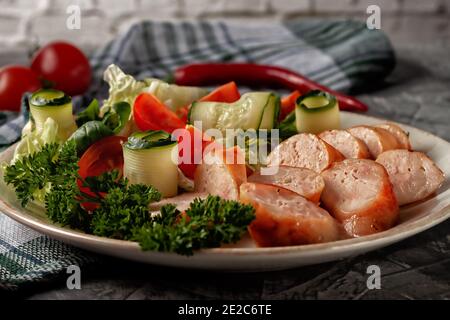 Fried homemade sausage on a platter with fresh vegetables Stock Photo