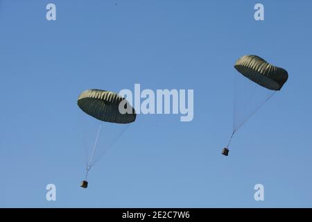 Military army parachutes paratroopers jump in blue sky from airplane ceremony day. Armed Forces special battalion staff exercise. National defense Stock Photo