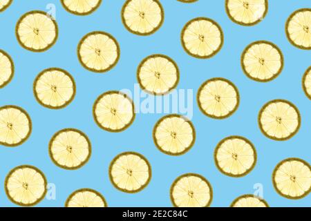 Pattern made of backlit lemon slices on blue background Stock Photo