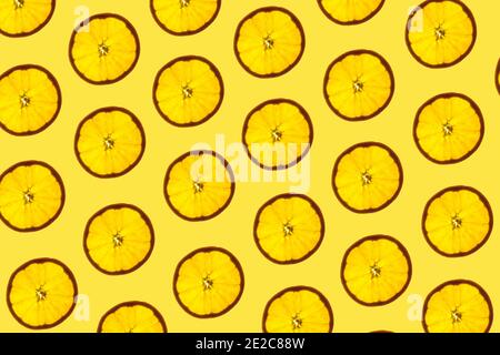 Pattern made of backlit orange slices on yellow background Stock Photo