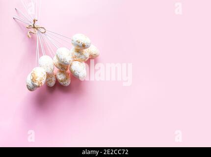 Easter composition with traditional decor of colorful eggs on sticks on soft pink pastel background Stock Photo