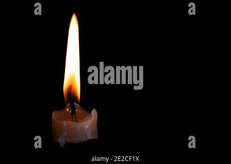 Light candle burning brightly in the black background Stock Photo
