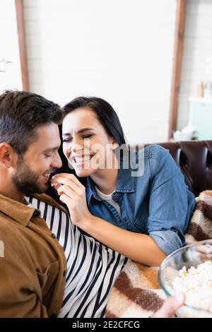 Cheerful woman in bra feeding sensual boyfriend with croissant near  breakfast on blurred foreground Stock Photo by LightFieldStudios