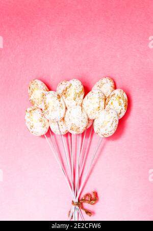 Easter vertical composition with traditional decor. Small decorative colorful eggs on pink background. Stock Photo