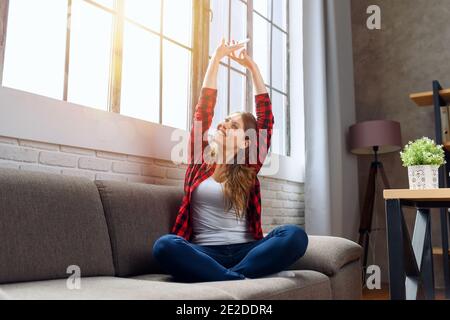 Happy woman relaxing on a sofa at home Stock Photo