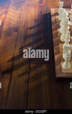 Shadows of chess pieces on a chess board. Stock Photo