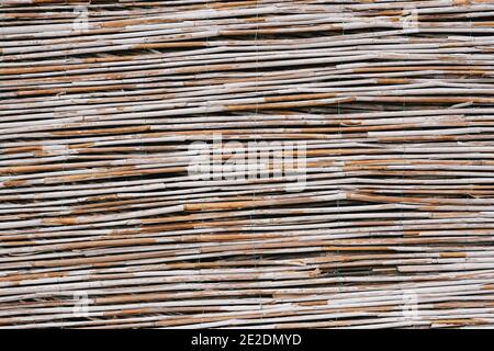Close-up texture of a fence made of bamboo twigs. Stock Photo