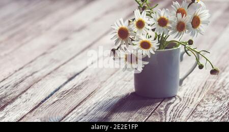 bouquet small white camomile flowers in the vase on old wooden table Stock Photo
