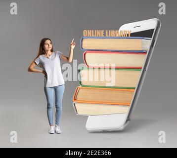 Woman near books on screen of mobile phone against grey background. Concept of online library Stock Photo