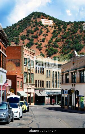 View down Main Street with restaurants and shopping in the old copper mining town of Bisbee, AZ, branded with an 'A' in white on a hilltop nearby Stock Photo