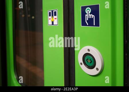 Close-up view at Green Push button for open the door on train's door of regional train in Germany. Stock Photo