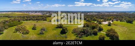 Wide aerial panoramic landscape of path winding through park with green grass and trees Stock Photo