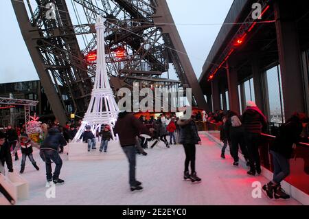 Skaters gliding along the ice on the first floor of the Eiffel Tower, 57 meters above ground level, on the first floor of the Eiffel Tower in Paris, France, December 20, 2011. The rink will only be in operation until February 1st. It is the second consecutive year that the ice skating rink opens in the Eiffel Tower. At 200 square meters (2,150 sq feet), it is only about a third of the size of New York's famed Rockefeller Center ice rink. Last year, more than 1,000 skaters visited the Tower's frozen surface, dubbed 'a popular success,' by organizers of the initiative. Skates can be hired for 5 Stock Photo