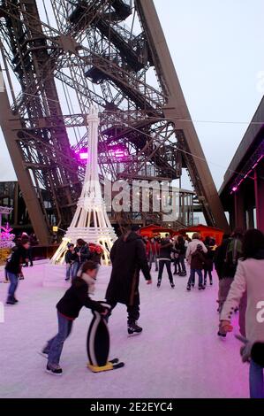 Skaters gliding along the ice on the first floor of the Eiffel Tower, 57 meters above ground level, on the first floor of the Eiffel Tower in Paris, France, December 20, 2011. The rink will only be in operation until February 1st. It is the second consecutive year that the ice skating rink opens in the Eiffel Tower. At 200 square meters (2,150 sq feet), it is only about a third of the size of New York's famed Rockefeller Center ice rink. Last year, more than 1,000 skaters visited the Tower's frozen surface, dubbed 'a popular success,' by organizers of the initiative. Skates can be hired for 5 Stock Photo