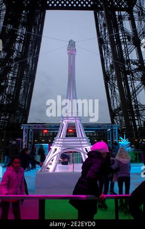 Skaters gliding along the ice on the first floor of the Eiffel Tower, 57 meters above ground level, on the first floor of the Eiffel Tower in Paris, France, December 20, 2011. The rink will only be in operation until February 1st. It is the second consecutive year that the ice skating rink opens in the Eiffel Tower. At 200 square meters (2,150 sq feet), it is only about a third of the size of New York's famed Rockefeller Center ice rink. Last year, more than 1,000 skaters visited the Tower's frozen surface, dubbed 'a popular success,' by organizers of the initiative. Skates can be hired for 5 Stock Photo