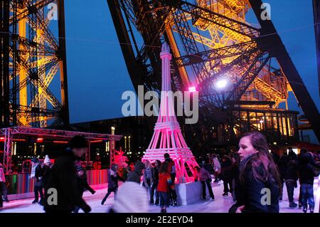 Skaters gliding along the ice on the first floor of the Eiffel Tower, 57 meters above ground level, on the first floor of the Eiffel Tower in Paris, France, December 20, 2011. The rink will only be in operation until February 1st. It is the second consecutive year that the ice skating rink opens in the Eiffel Tower. At 200 square meters (2,150 sq feet), it is only about a third of the size of New York's famed Rockefeller Center ice rink. Last year, more than 1,000 skaters visited the Tower's frozen surface, dubbed 'a popular success,' by organizers of the initiative. Skates can be hired for 5 Stock Photo