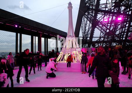 Skaters gliding along the ice on the first floor of the Eiffel Tower, 57 meters above ground level, on the first floor of the Eiffel Tower in Paris, France, December 20, 2011. The rink will only be in operation until February 1st. It is the second consecutive year that the ice skating rink opens in the Eiffel Tower. At 200 square meters (2,150 sq feet), it is only about a third of the size of New York's famed Rockefeller Center ice rink. Last year, more than 1,000 skaters visited the Tower's frozen surface, dubbed 'a popular success,' by organizers of the initiative. Skates can be hired for 5 Stock Photo