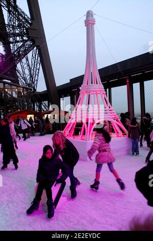 Skaters gliding along the ice on the first floor of the Eiffel Tower, 57 meters above ground level, on the first floor of the Eiffel Tower in Paris, France, December 20, 2011. The rink will only be in operation until February 1st. It is the second consecutive year that the ice skating rink opens in the Eiffel Tower. At 200 square meters (2,150 sq feet), it is only about a third of the size of New York's famed Rockefeller Center ice rink. Last year, more than 1,000 skaters visited the Tower's frozen surface, dubbed 'a popular success,' by organizers of the initiative. Skates can be hired for 5 Stock Photo