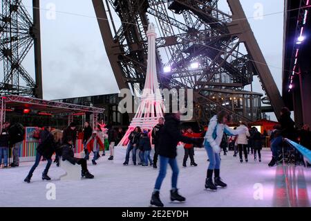 Skaters gliding along the ice on the first floor of the Eiffel Tower, 57 meters above ground level, on the first floor of the Eiffel Tower in Paris, France, December 20, 2011. The rink will only be in operation until February 1st. It is the second consecutive year that the ice skating rink opens in the Eiffel Tower. At 200 square meters (2,150 sq feet), it is only about a third of the size of New York's famed Rockefeller Center ice rink. Last year, more than 1,000 skaters visited the Tower's frozen surface, dubbed 'a popular success,' by organizers of the initiative. Skates can be hired for 5 Stock Photo