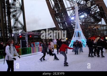 Skaters gliding along the ice on the first floor of the Eiffel Tower, 57 meters above ground level, on the first floor of the Eiffel Tower in Paris, France, December 20, 2011. The rink will only be in operation until February 1st. It is the second consecutive year that the ice skating rink opens in the Eiffel Tower. At 200 square meters (2,150 sq feet), it is only about a third of the size of New York's famed Rockefeller Center ice rink. Last year, more than 1,000 skaters visited the Tower's frozen surface, dubbed 'a popular success,' by organizers of the initiative. Skates can be hired for 5 Stock Photo