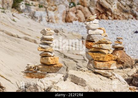 cairn of yellow stones at rocky beach Stock Photo