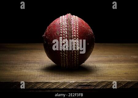 Leather Cricket ball close-up on a wooden surface fine art with copy space Stock Photo