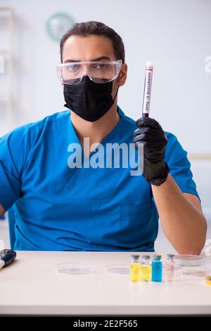 Male biochemist testing blood samples Stock Photo - Alamy