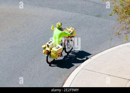 Perth, Australia - September 24, 2020: Postman on a bicycle working for Australia Post