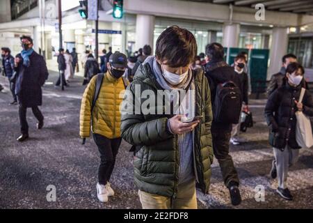 Kawasaki, Japan. 13th Jan, 2021. Pedestrians with face masks cross the road near Keikyu Kawasaki Station. Credit: SOPA Images Limited/Alamy Live News Stock Photo