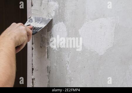 The man is plastering the walls in the room. Close-up. Stock Photo
