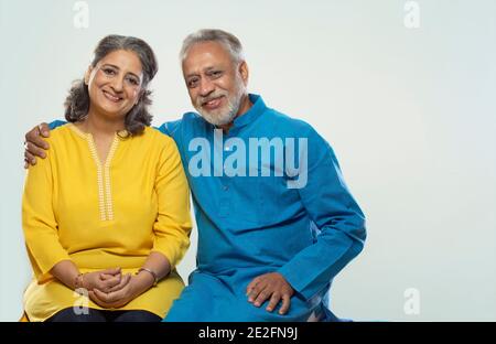 AN SENIOR COUPLE HAPPILY LOOKING AT CAMERA AND SMILING Stock Photo