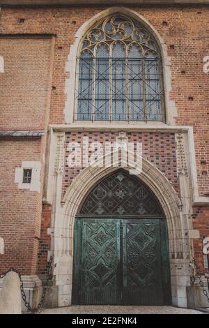 two-leaf metal door under a semicircular arch of stone with a beautiful window  Stock Photo