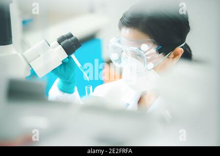 Doctor or scientist using pipette to drop a sample to test tube in medical research lab or science laboratory Stock Photo