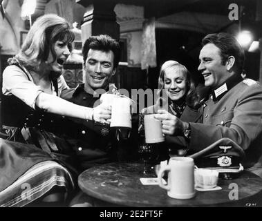 INGRID PITT CLINT EASTWOOD MARY URE and RICHARD BURTON on set candid portrait clinking beer mugs during filming of WHERE EAGLES DARE 1968 director BRIAN G. HUTTON story / screenplay Alistair MacLean music Ron Goodwin producers Elliot Kastner and Jerry Gershwin  Gershwin-Kastner Productions / Winkast Film Productions / Metro Goldwyn Mayer Stock Photo