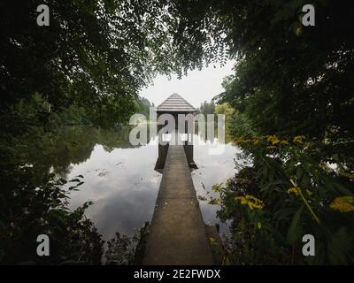 Wooden walkway leading to old boat house on lake Muehlteich Muhlteich Woerthersee Moosburg Carinthia Austria in Europe Stock Photo