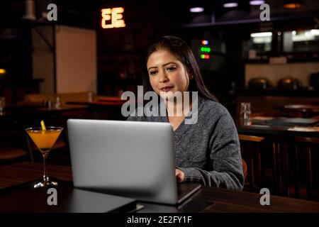 Portrait of a business woman working on her laptop in a restaurant, social media concept, video conferencing. Stock Photo