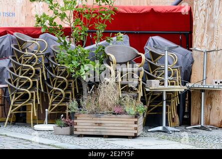 Berlin, Germany. 13th Jan, 2021. Tables and chairs of a cafe are stacked and arranged with green plants. Due to the lockdown, shops, cafes and restaurants are closed. Credit: Jens Kalaene/dpa-Zentralbild/ZB/dpa/Ģ����ý Live News Stock Photo